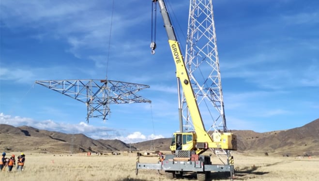 Grúa instalando postes de alta tensión